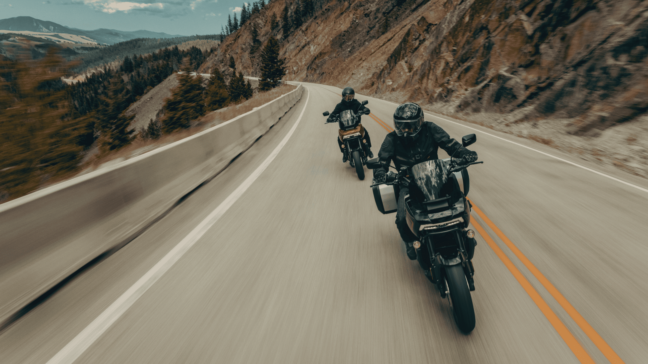 Two riders navigate winding mountain roads on The 2025 Harley-Davidson® Adventure Touring Motorcycle…