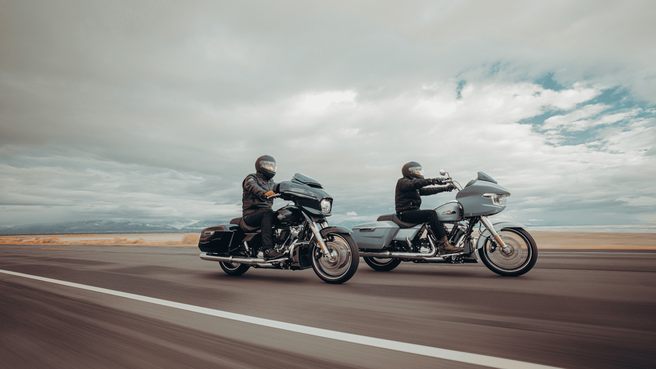 Two riders cruise along an open highway on The 2025 Harley-Davidson® Grand American Touring Motorcyc…