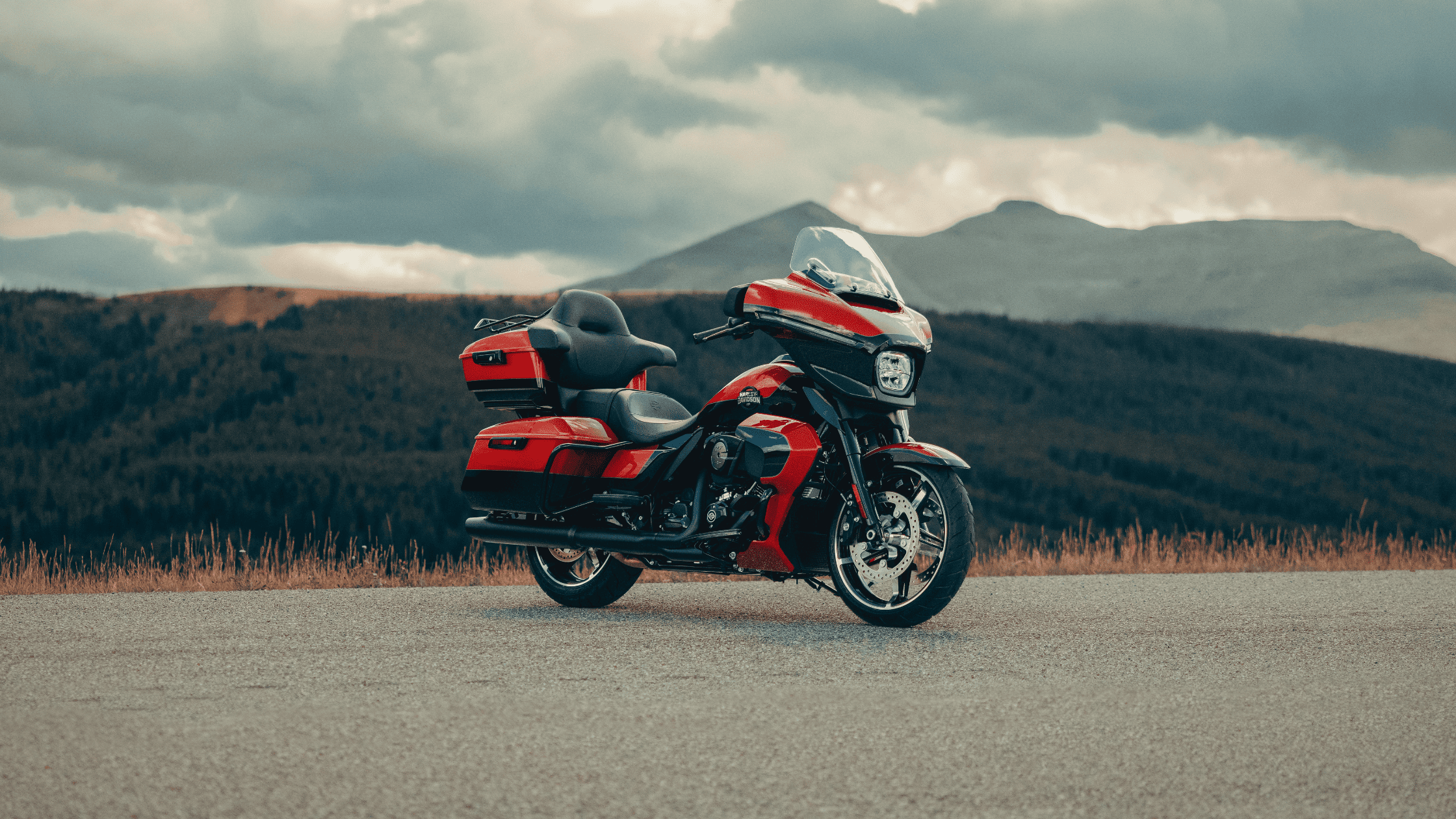 Red 2025 Harley-Davidson® Street Glide® Ultra parked on a road with mountains in the background near Mount Pleasant, TN.
