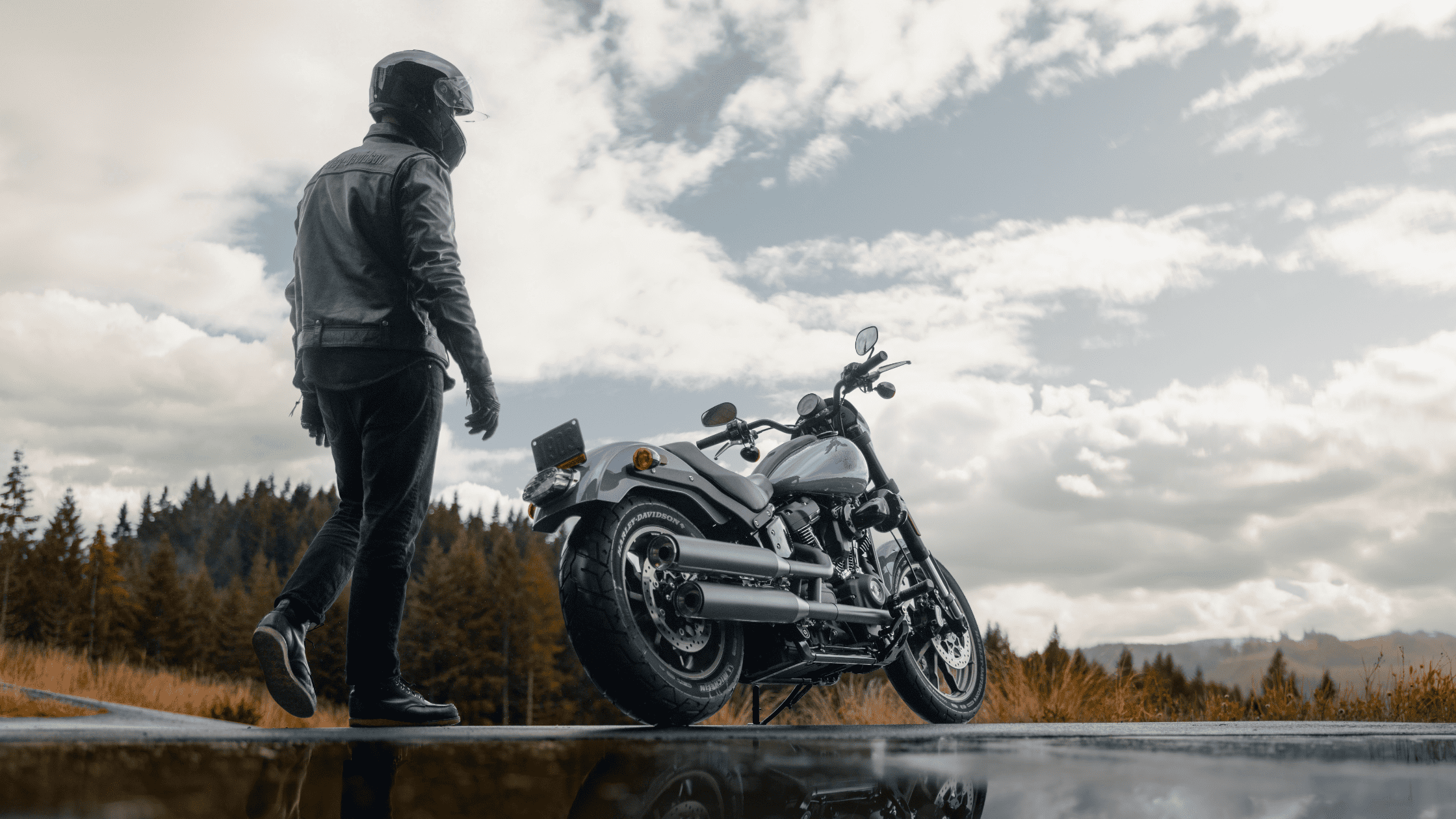 . A man stands next to a 2024 Harley-Davidson® Low Rider® S, ready for adventure on a road near Moun…