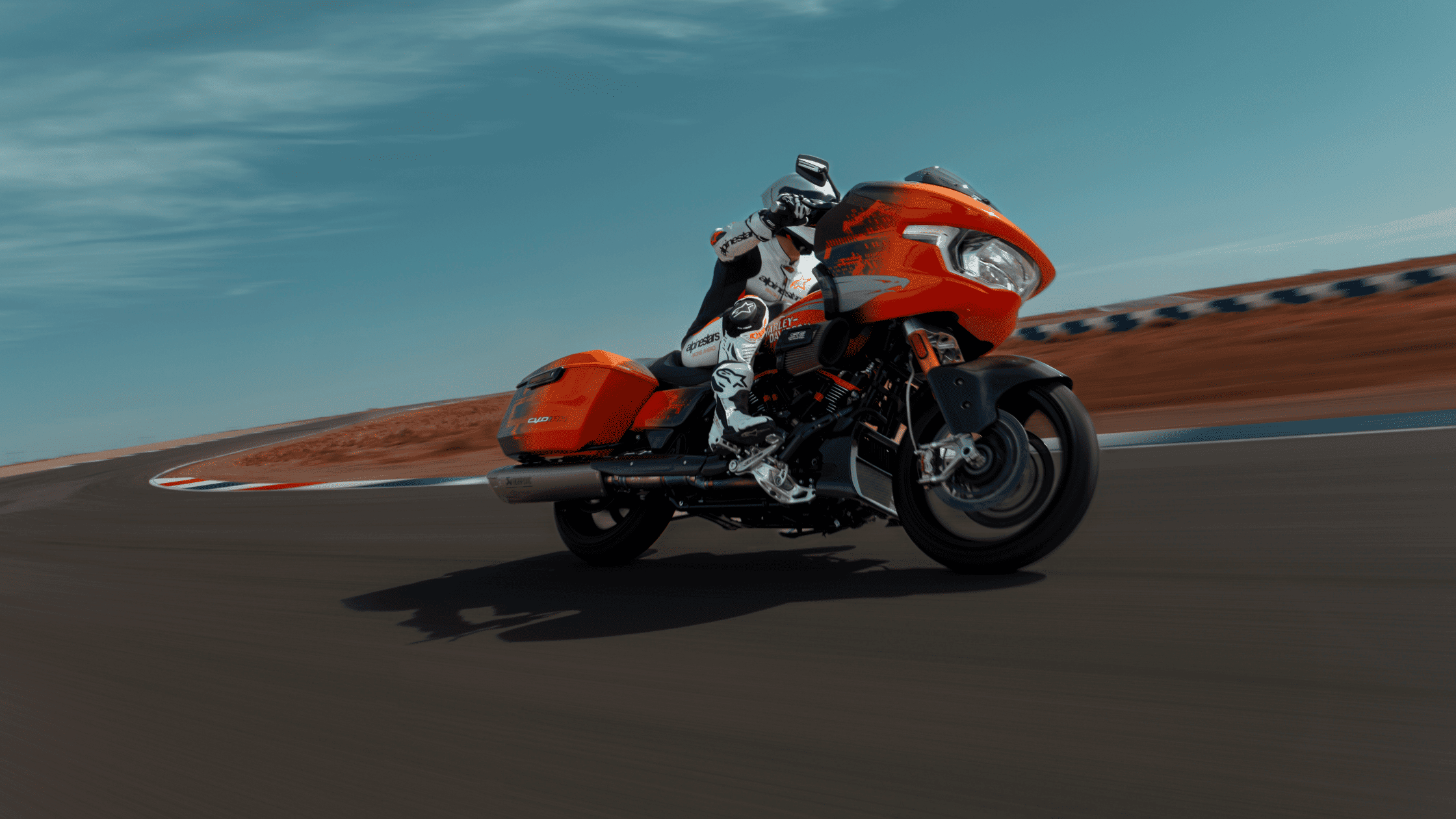 A man rides an orange 2025 Harley-Davidson® CVO™ Road Glide® RR motorcycle on a track in Nashville, TN.